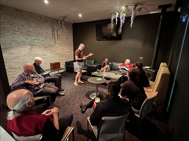 Members gathered in the meeting room as a member addresses the group