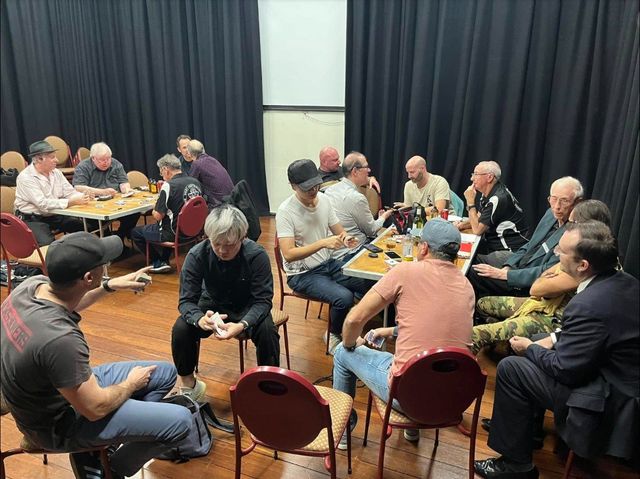 Several tables of members sharing magic at the May 2024 meeting